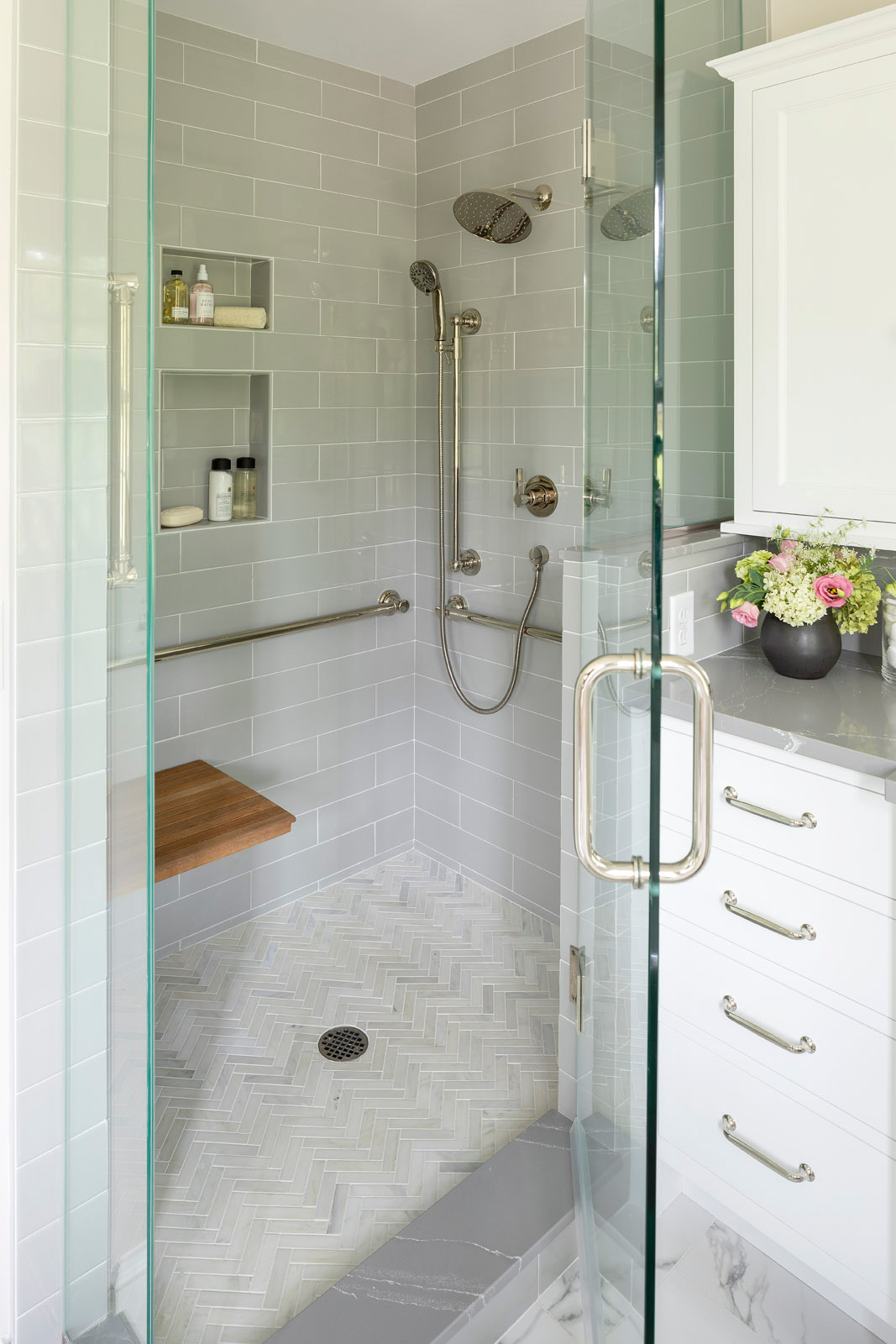 shower with grey field tile and herringbone floor tile