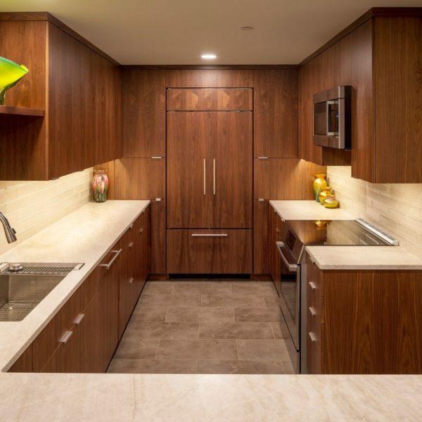 small kitchen with paneled fridge and countertops