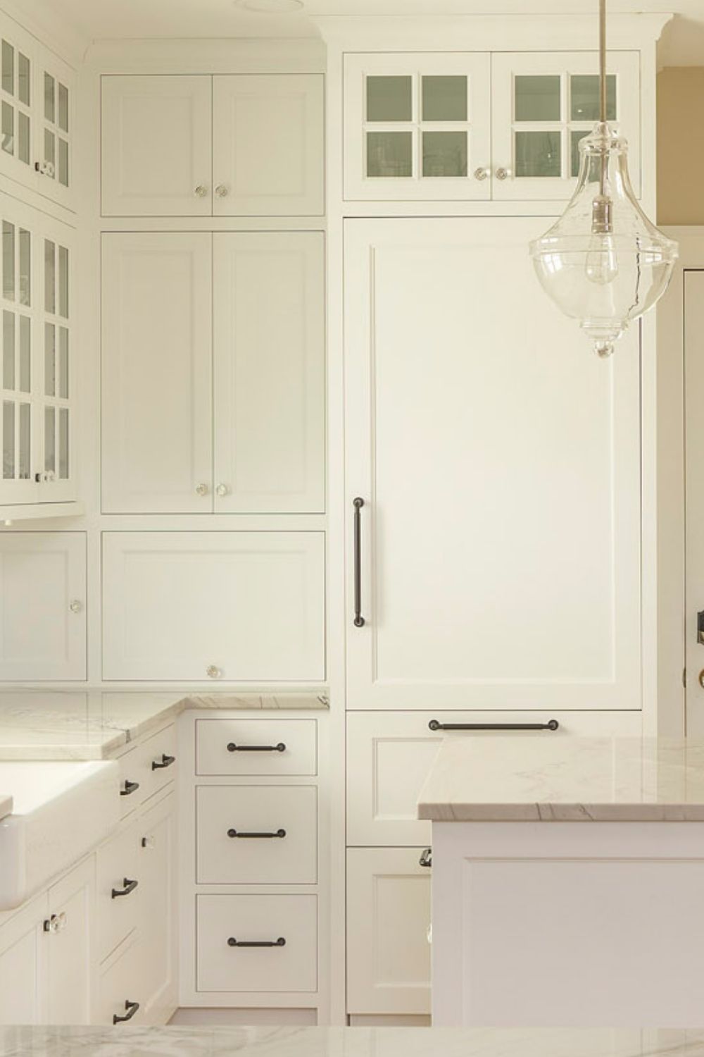 tall and narrow paneled fridge, white glass cabinets and drawers