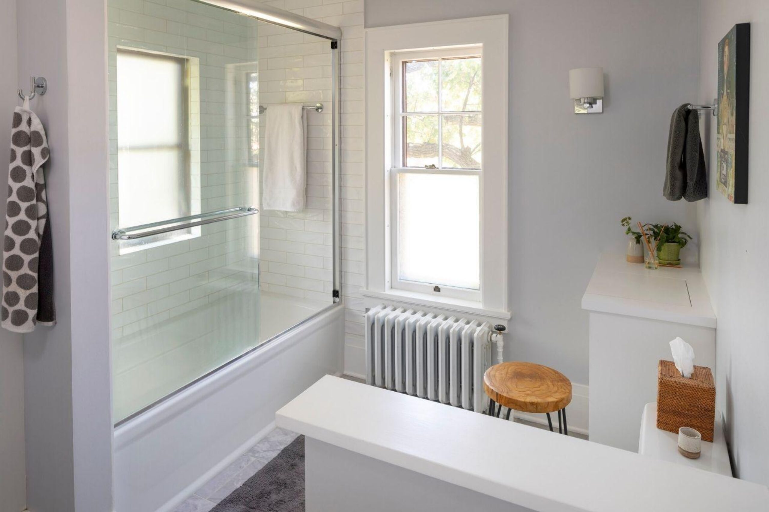 bright and revamped bathroom with privacy wall and soaker tub, glass door to shower