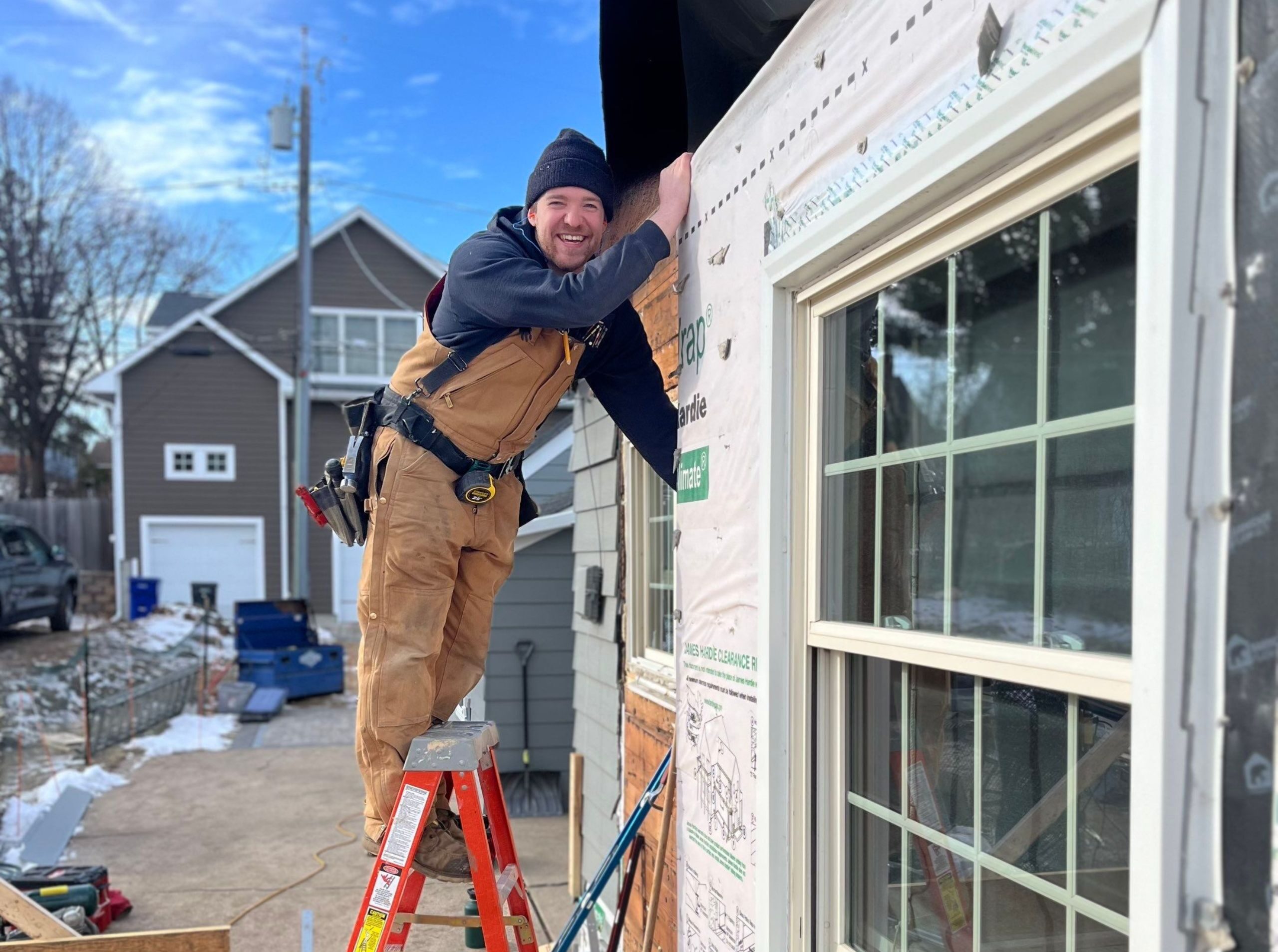 carpenter standing on ladder outside