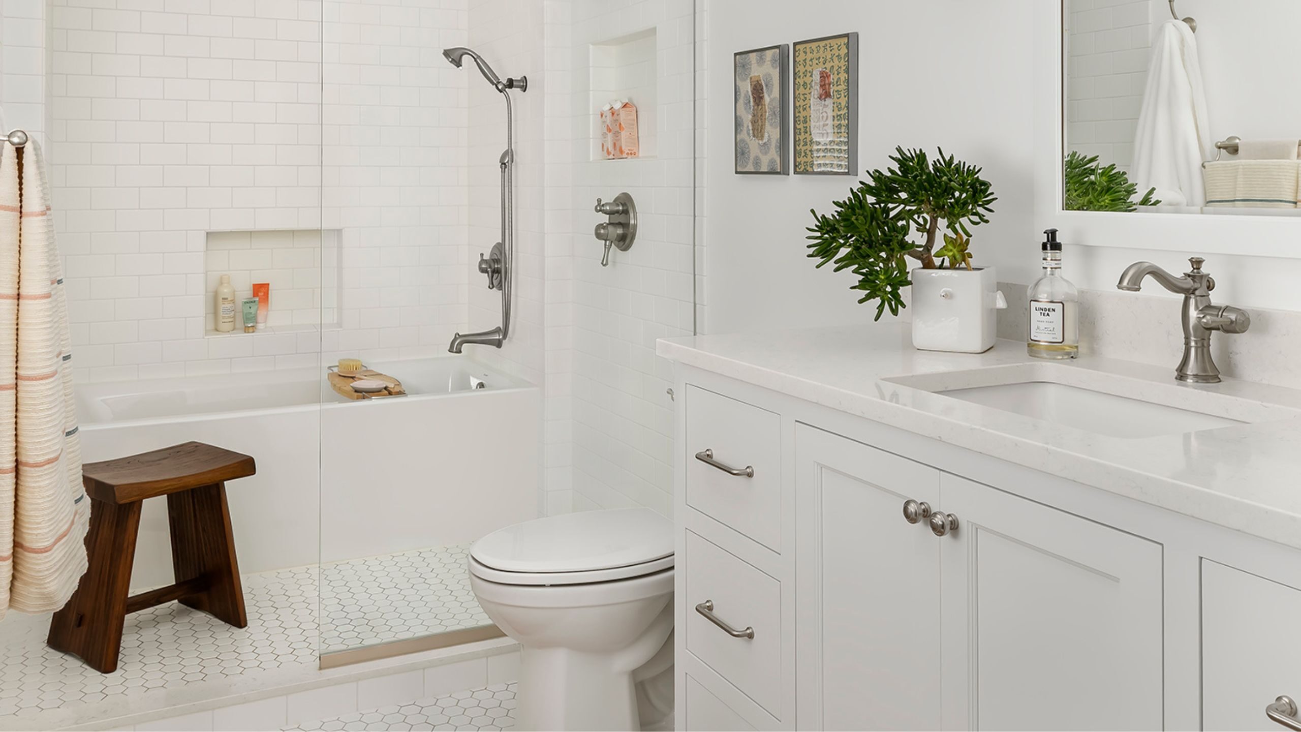 Timeless all-white primary bathroom with tub, shower, and custom vanity