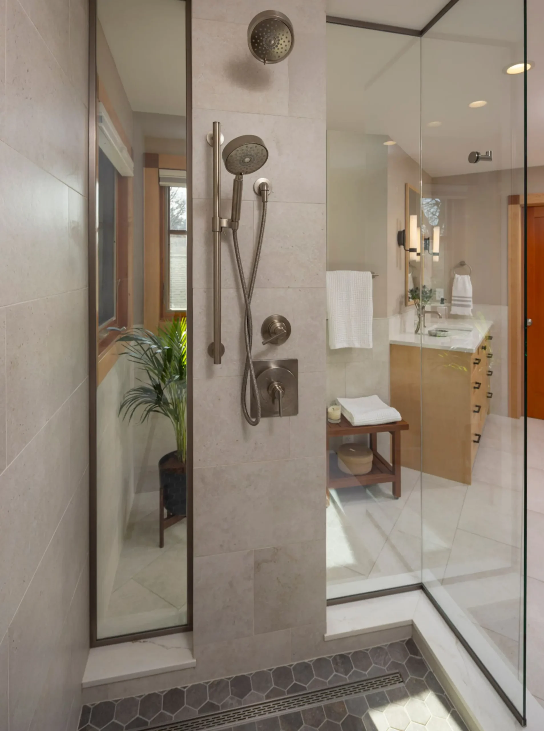 glass shower with detachable shower head, linear drain, and hex tile flooring