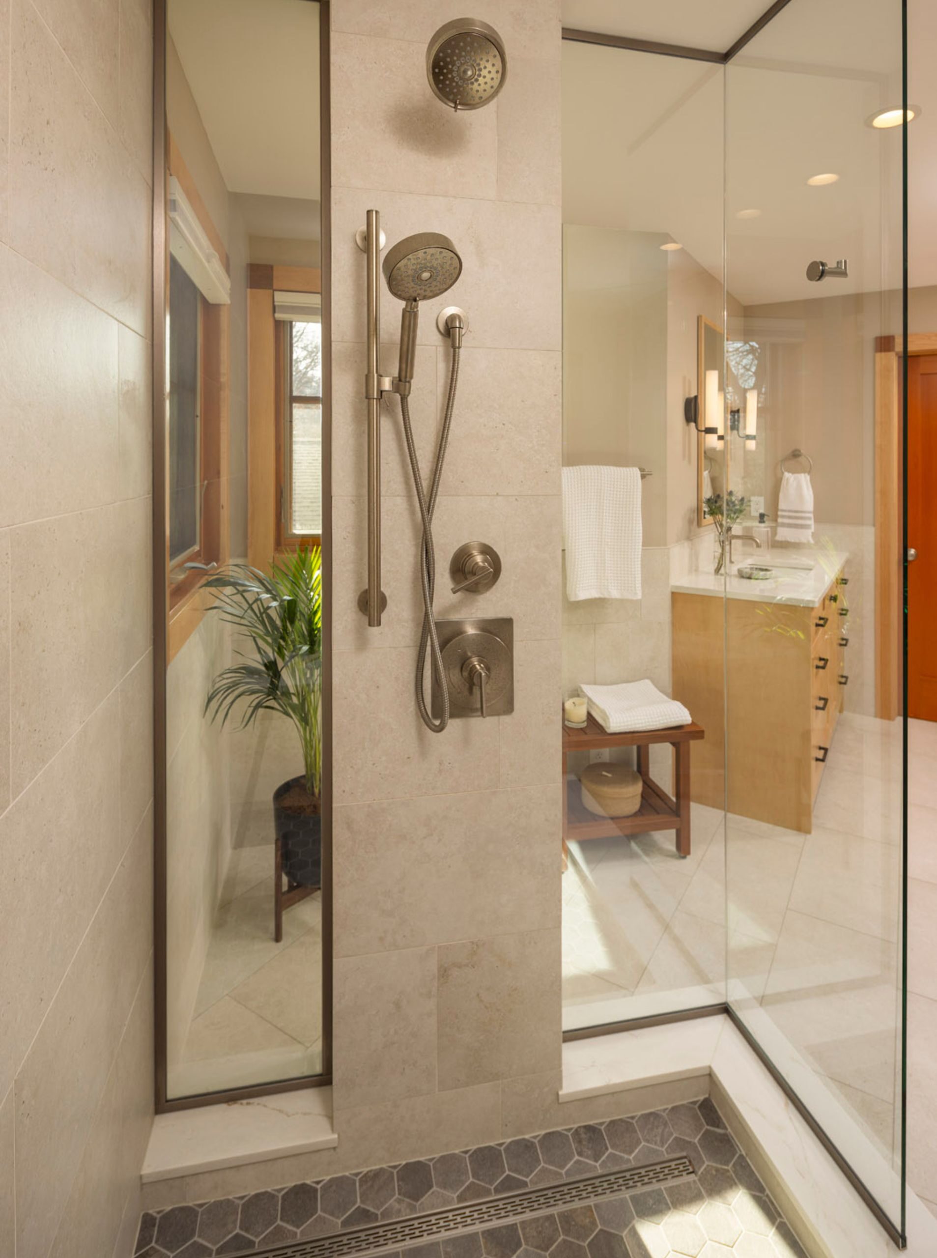 glass shower with detachable shower head, linear drain, and hex tile flooring
