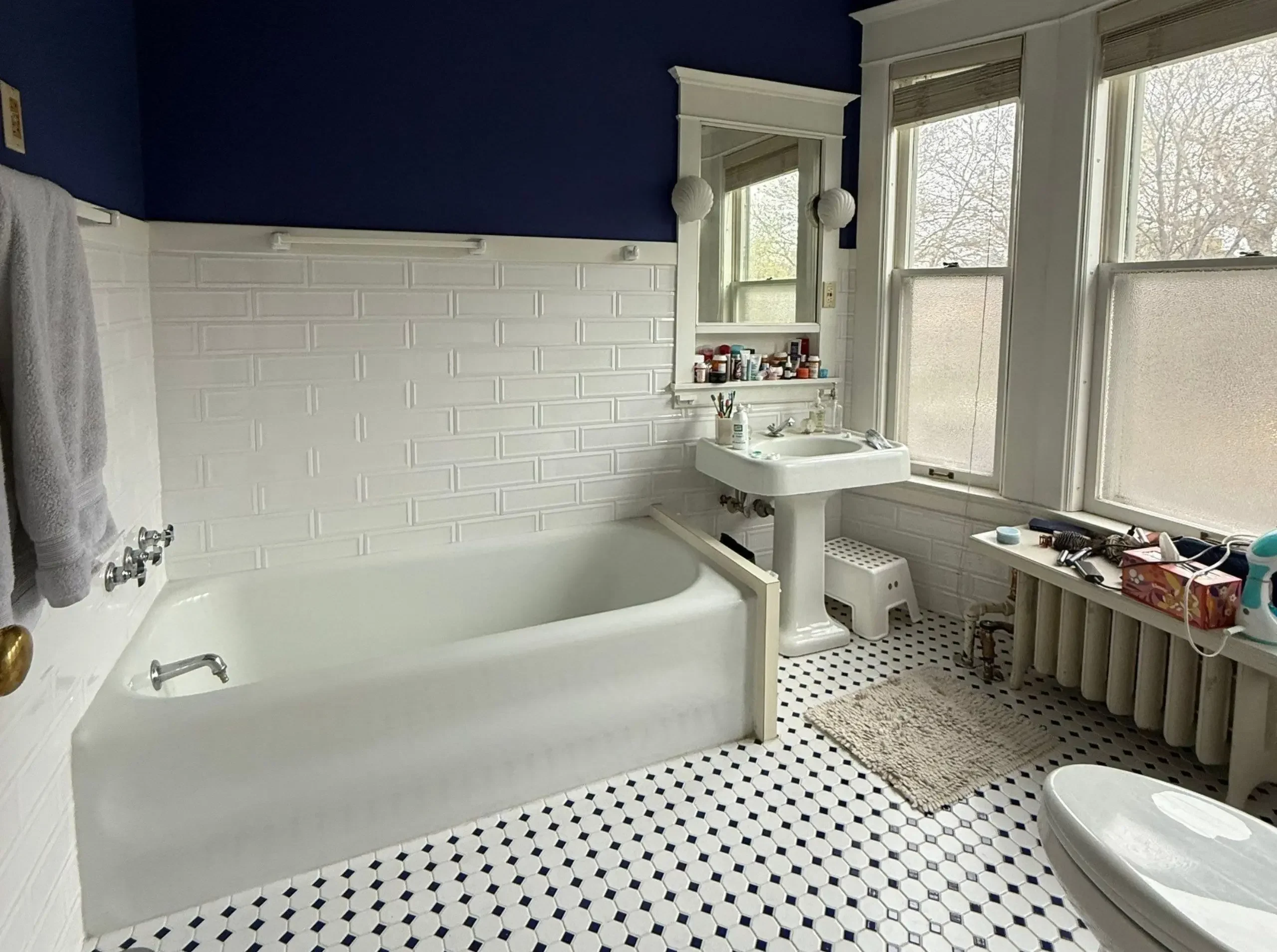 before tub and pedestal sink in vintage home