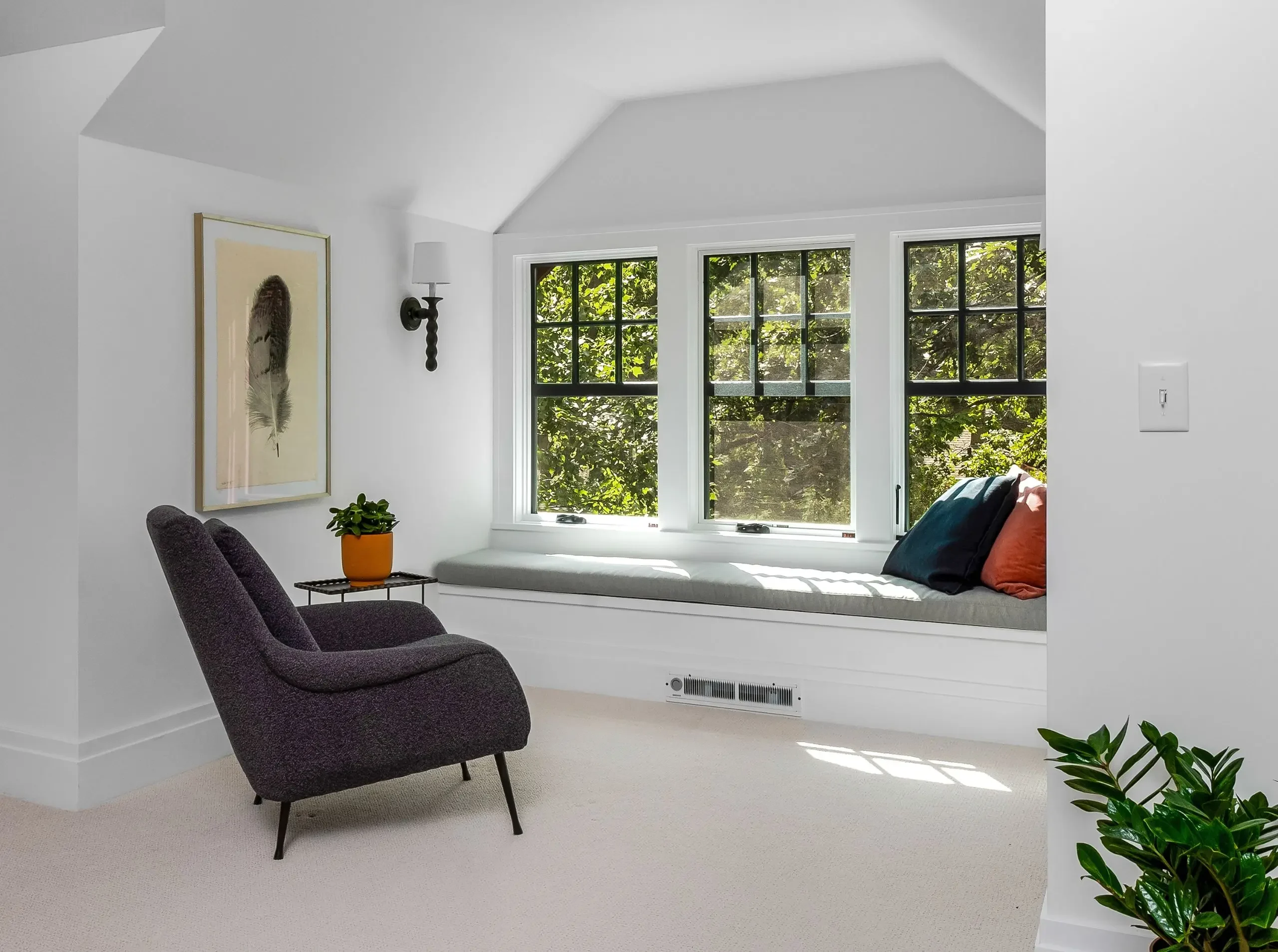 Dormer addition brings natural light into a remodeled attic with a cozy sitting area.