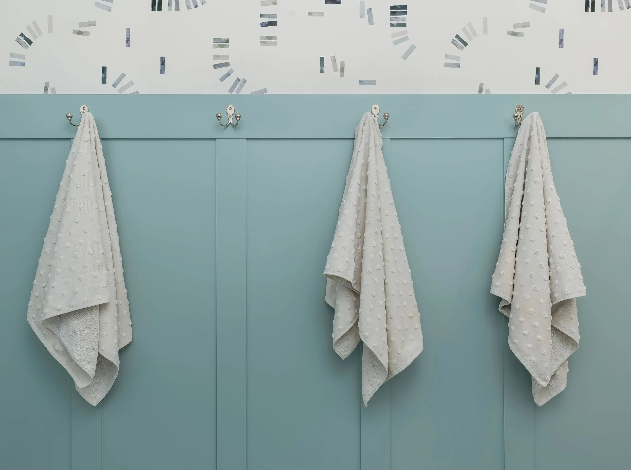 Traditional bathroom featuring paneled wainscoting and geometric wallpaper