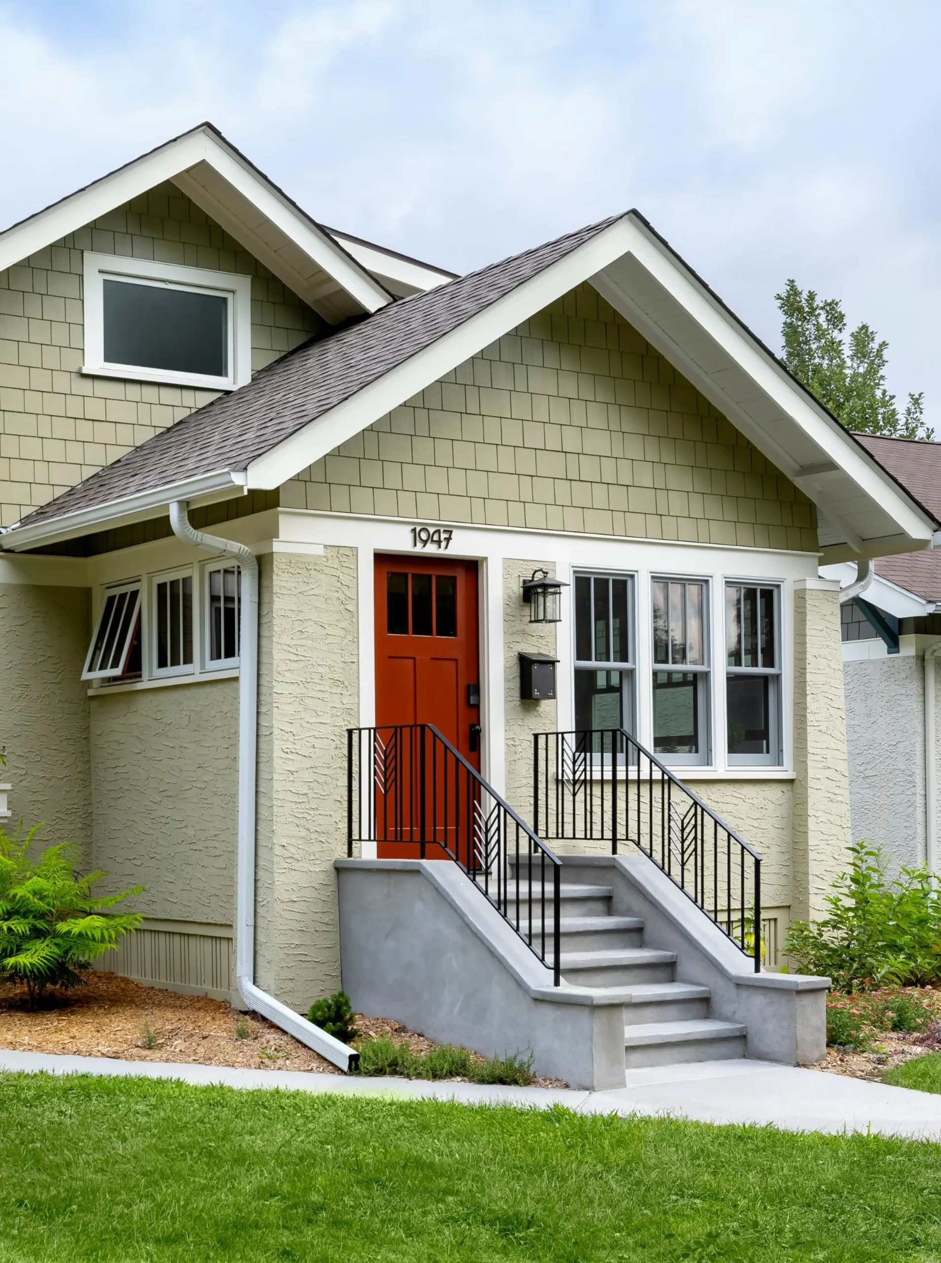 Bungalow front entry with custom metal railings, orange door and restored exterior details